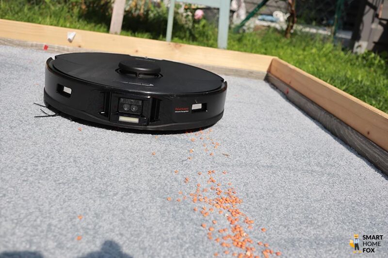 Der Roborock S7 MaxV Ultra saugt im Test Linsen auf einen Teppich